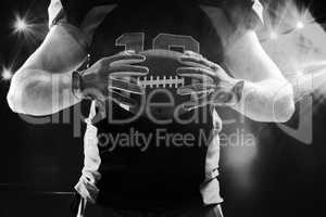 American football player in helmet holding rugby ball