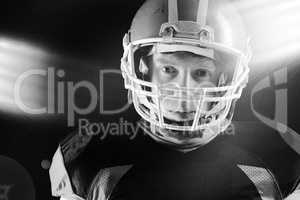 American football player in helmet standing against black background