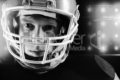 American football player in helmet standing against black background