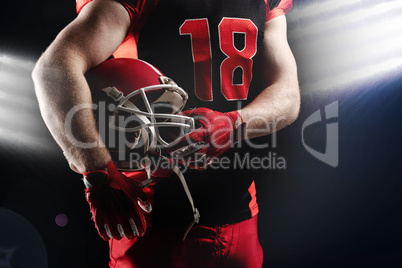 American football player holding rugby helmet