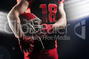 American football player holding rugby helmet