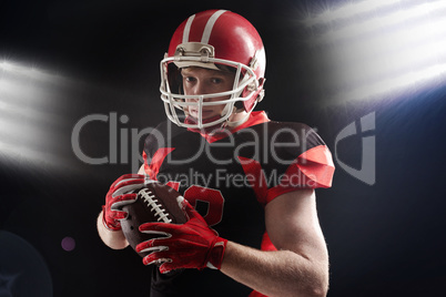 American football player in helmet holding rugby ball