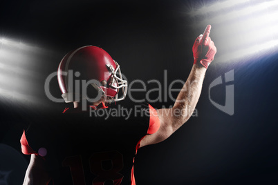 American football player in helmet pointing upwards