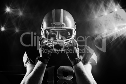American football player standing with rugby helmet