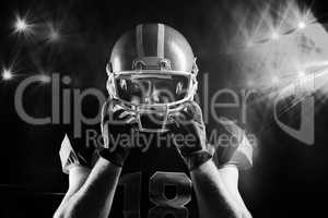 American football player standing with rugby helmet