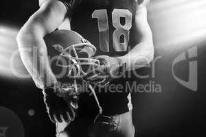 American football player holding rugby helmet