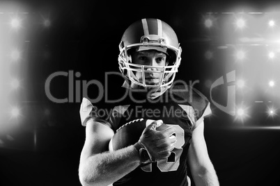 American football player in helmet holding rugby ball