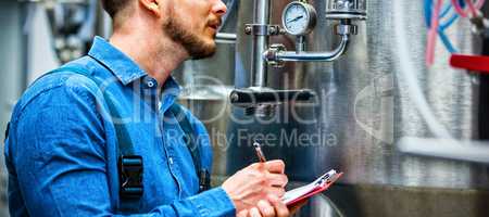 maintenance worker writing on clipboard