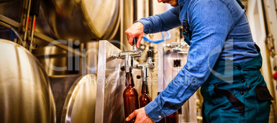 Brewer filling beer in bottle