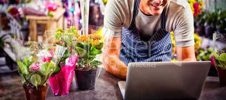 Male florist using laptop