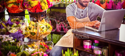 Male florist using laptop