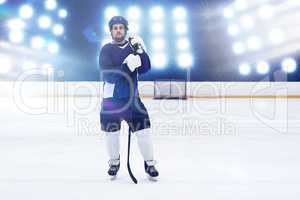 Composite image of hockey player with hockey stick standing on rink