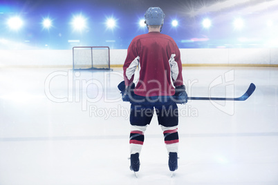 Composite image of rear view of hockey player at ice rink