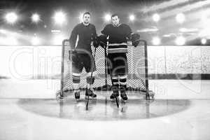 Composite image of ice hockey players standing by goal post