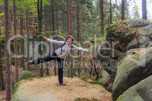 Woman is doing gymnastics in the forest
