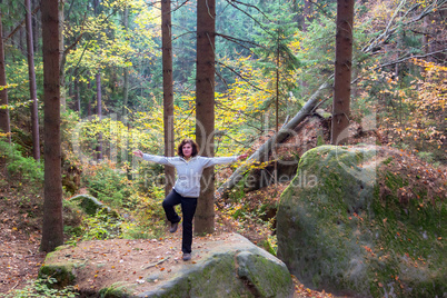 Woman is doing gymnastics in the forest