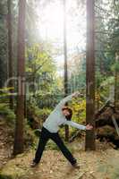 Woman is doing gymnastics in the forest