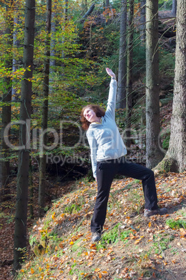 Woman is doing gymnastics in the forest