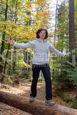 Woman is doing gymnastics in the forest