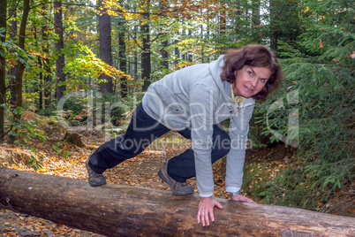 Woman is doing gymnastics in the forest