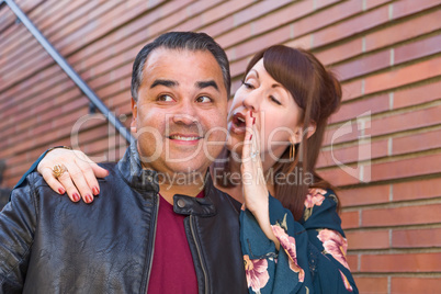 Caucasian Woman Whispering Secret to Hispanic Man