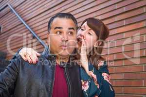 Caucasian Woman Whispering Secret to Hispanic Man