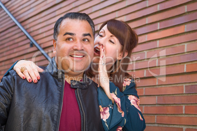 Caucasian Woman Whispering Secret to Hispanic Man