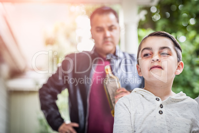Afraid and Bruised Mixed Race Boy In Front of Angry Man