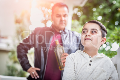 Afraid and Bruised Mixed Race Boy In Front of Angry Man Holding