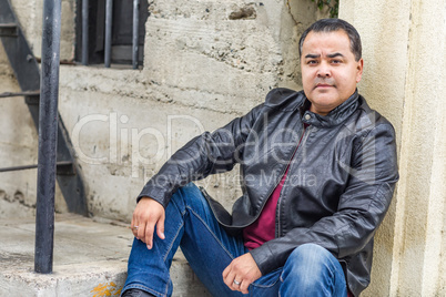 Handsome Hispanic Man in a Black Leather Jacket Poses in a Stairway