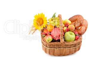 A set of fruits and pastries in a woven basket isolated on white
