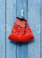 red leather boxing gloves hang on a nail