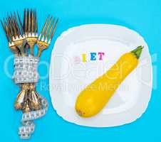 yellow squash on a white ceramic plate, next to a pile of iron f