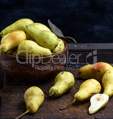 ripe green pears in a brown clay bowl