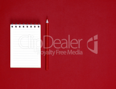 notebook with empty white sheets in line and red wooden pencil