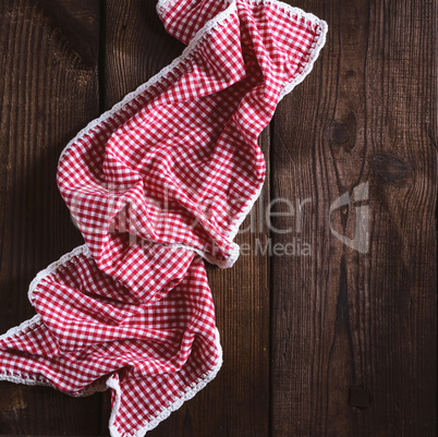 red textile towel in a white cell on a brown wooden  background