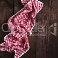 red textile towel in a white cell on a brown wooden  background