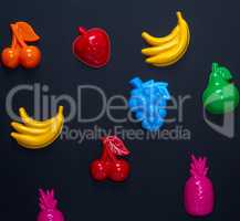 multicolored plastic toys fruits on a black background