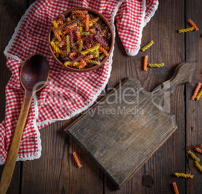 raw pasta fusilli on a brown wooden table