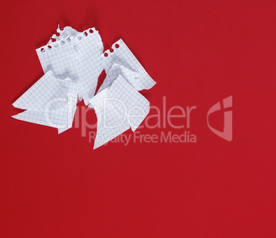 torn to pieces a white sheet of paper on a red background