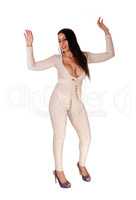 Woman dancing in silver jumpsuit with eyes closed