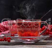 Fresh hot tea from viburnum berries in a transparent glass cup
