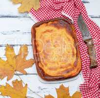 whole rectangular pie of cottage cheese and pumpkin on a white w