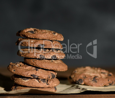 stack of round chocolate chip cookies on brown paper
