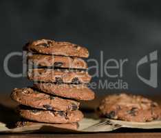 stack of round chocolate chip cookies on brown paper