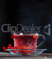 hot viburnum tea in a transparent cup with a handle