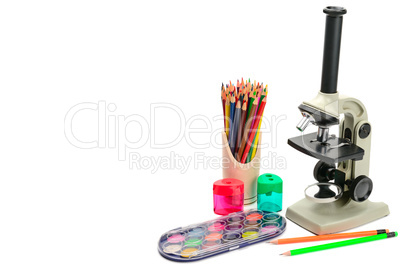 Microscope and other school supplies isolated on white backgroun