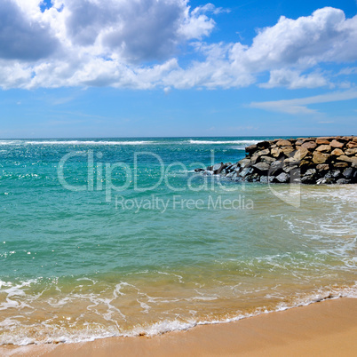 Deserted sandy beach of the Indian Ocean. In the blue sky cumulu