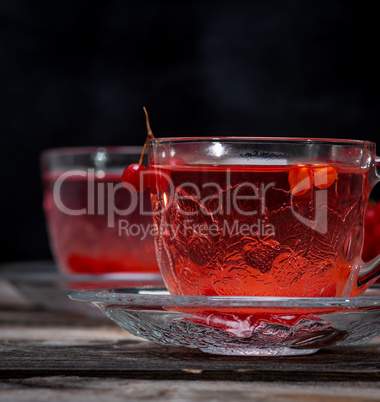 viburnum tea in a transparent cup with a handle and saucer