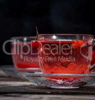 viburnum tea in a transparent cup with a handle and saucer